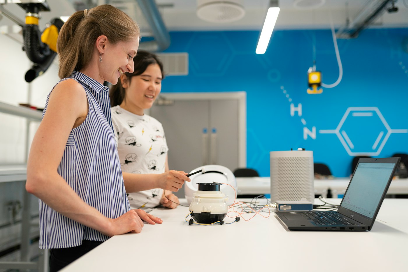 Two researchers in a bright laboratory looking at a sample together