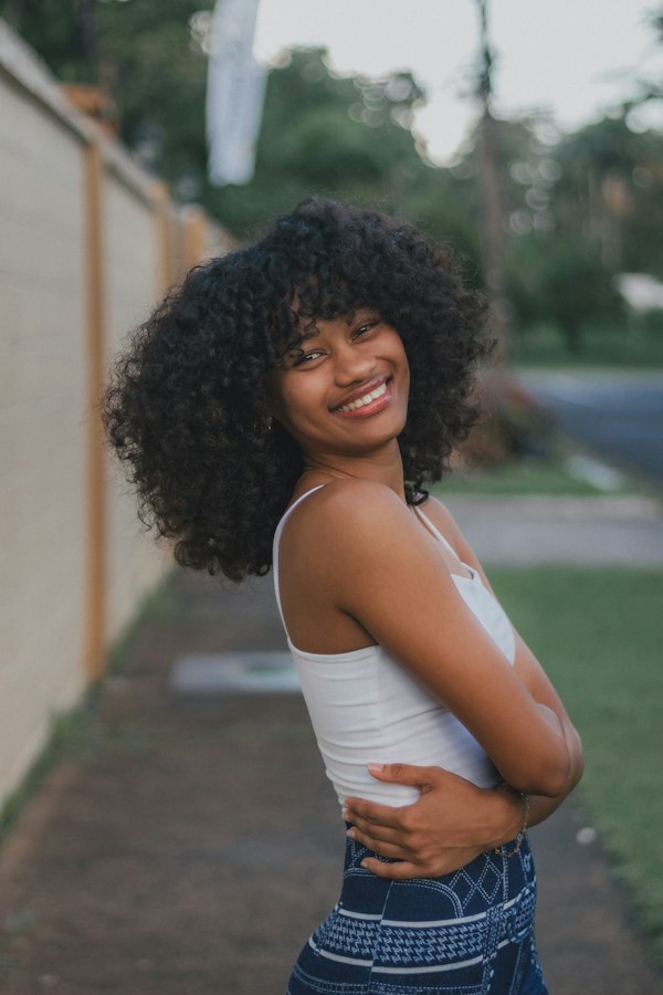 A young woman with curly hair smiling