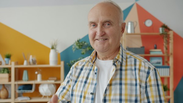 An older bald man in a checked shirt smiling